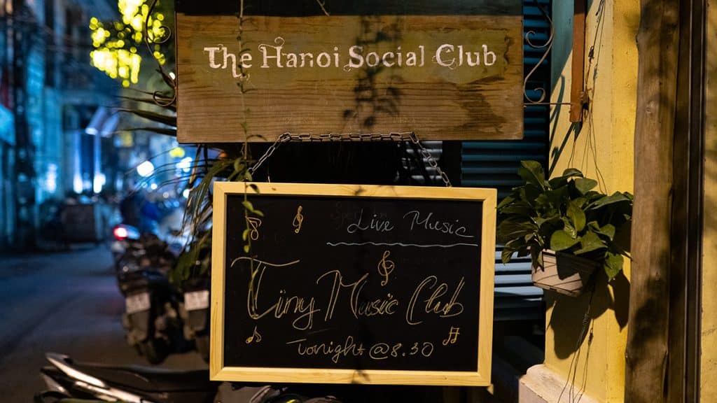 The Hanoi Social Club wooden sign and Tiny Music Club chalkboard at the entrance