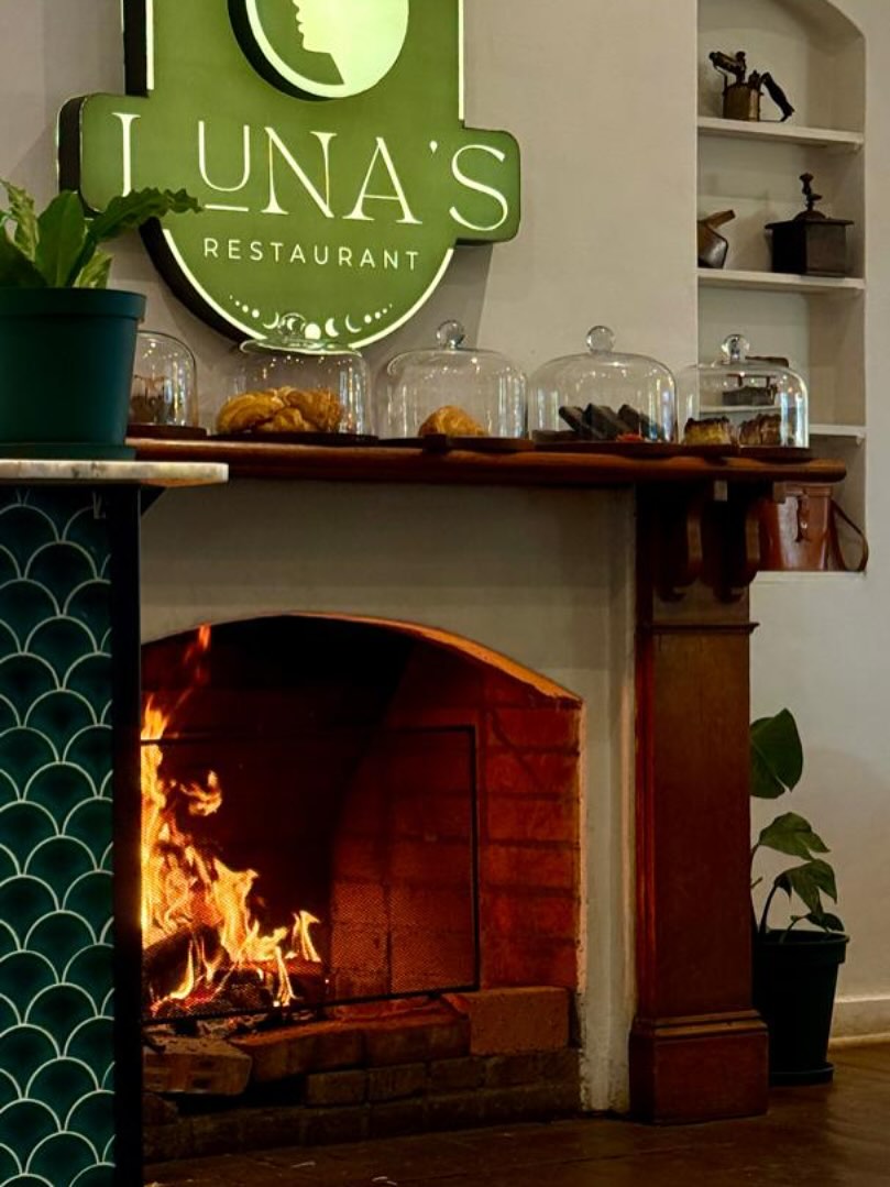Luna's Restaurant fireplace with iconic green Luna's sign