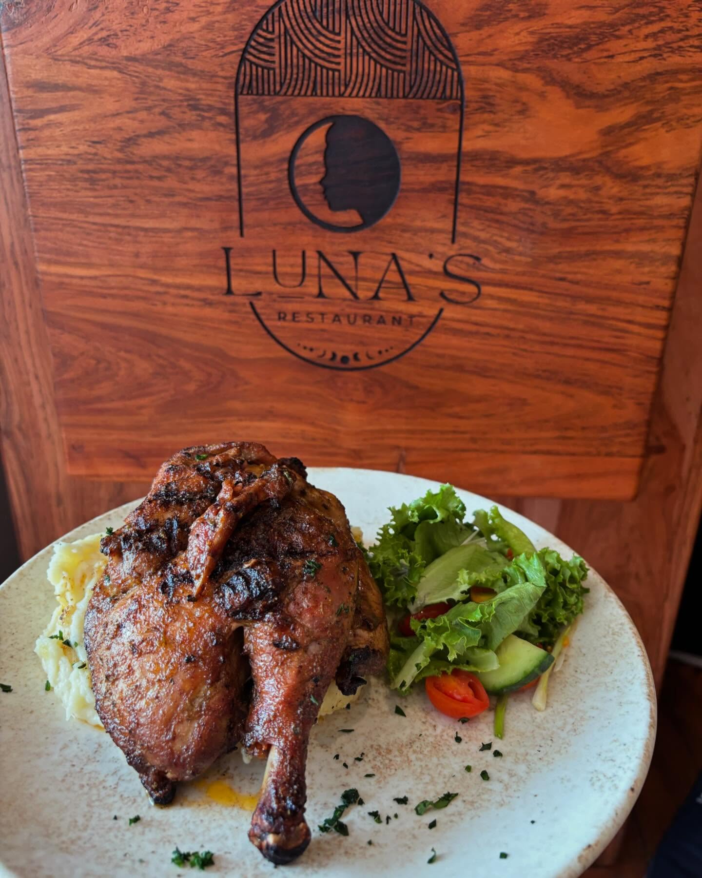 Roast chicken with Luna's wooden logo sign behind