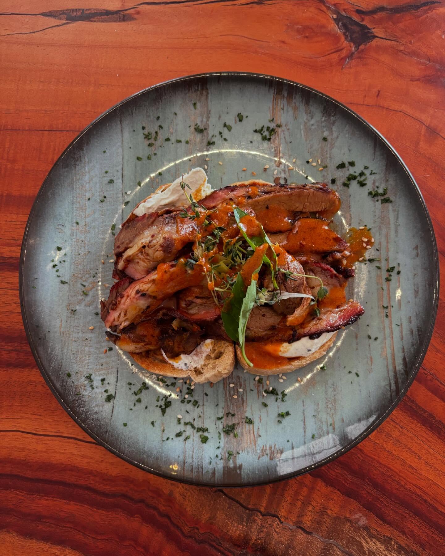 Sliced grilled meat on grey-blue plate at Luna's