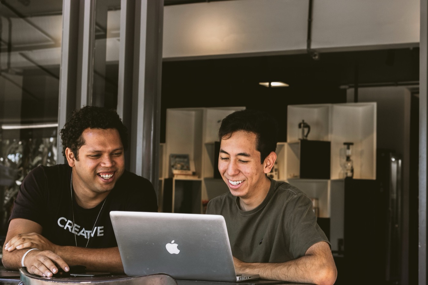 Two people meeting over laptops in a Chiang Mai café