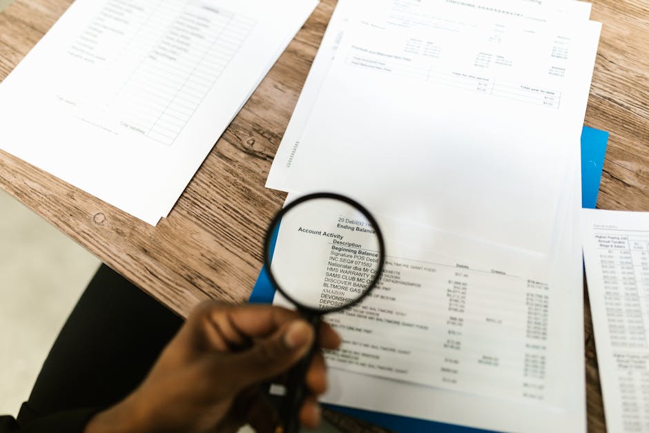 Magnifying glass examining financial documents
